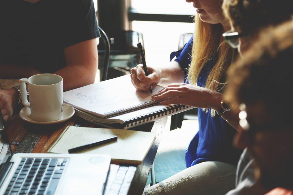 Equipo de trabajo revisando un proyecto con ordenadores y documentos